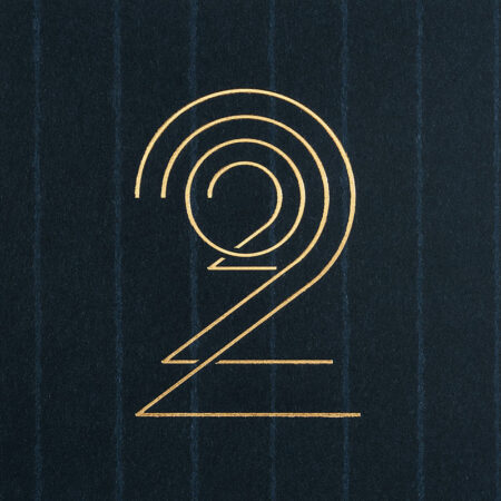Cette photo représente un zoom de la carte de vœux modèle Glyphe, de la collection Intaglio 2022, sur une carte Bleu Savile Row, avec le détail des gravures Or.