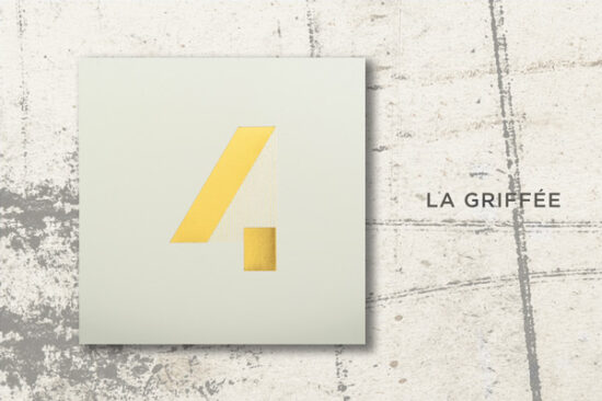 Mise en scène du modèle de carte de voeux de luxe 2024, La Griffée, dans sa version Or sur Bianco, sur un fond original.