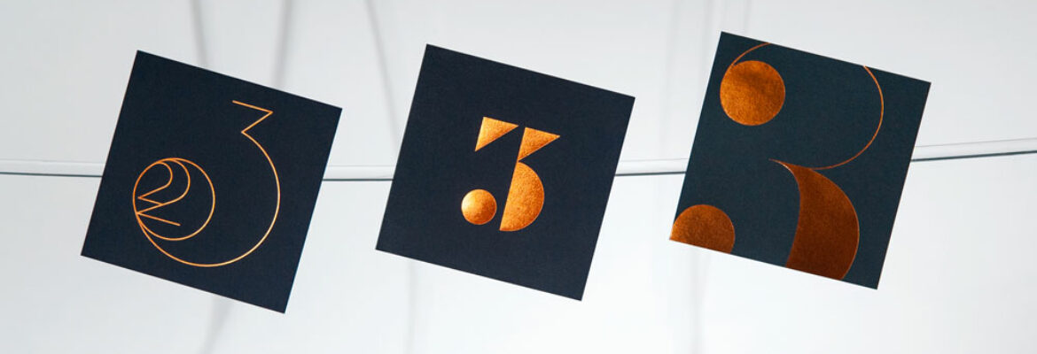 Cette photo utilisée en bandeau sur la page Home du site et donnant l'accès à la page de Cartes de Voeux 2023, représente les cartes de voeux haut de gamme Voltige, Numéro et Jumbo, toutes les trois en Bleu Savile, avec leurs designs gravés en Dorure Cuivre.