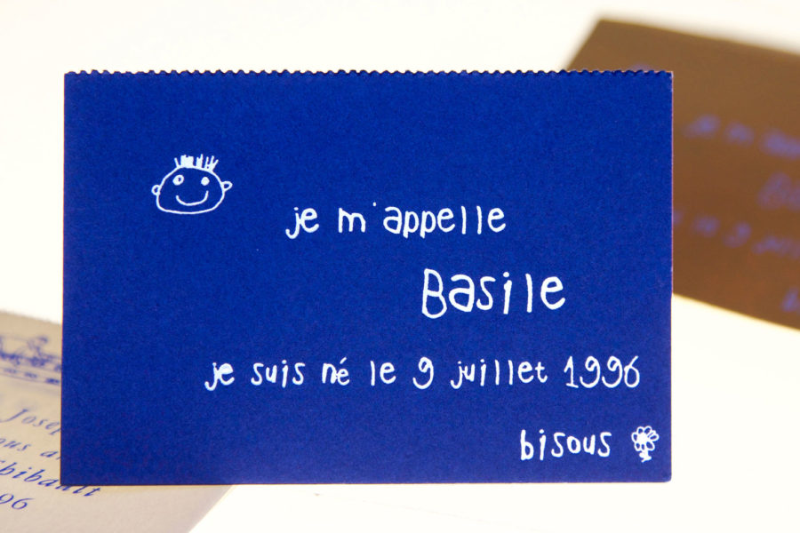 Cette photo représente le faire-part de naissance crée par Stéphane Le Sauter pour la naissance de son fils Basile en 1996, Gravure à chaud pigment blanc sur papier bleu carte-chevalet