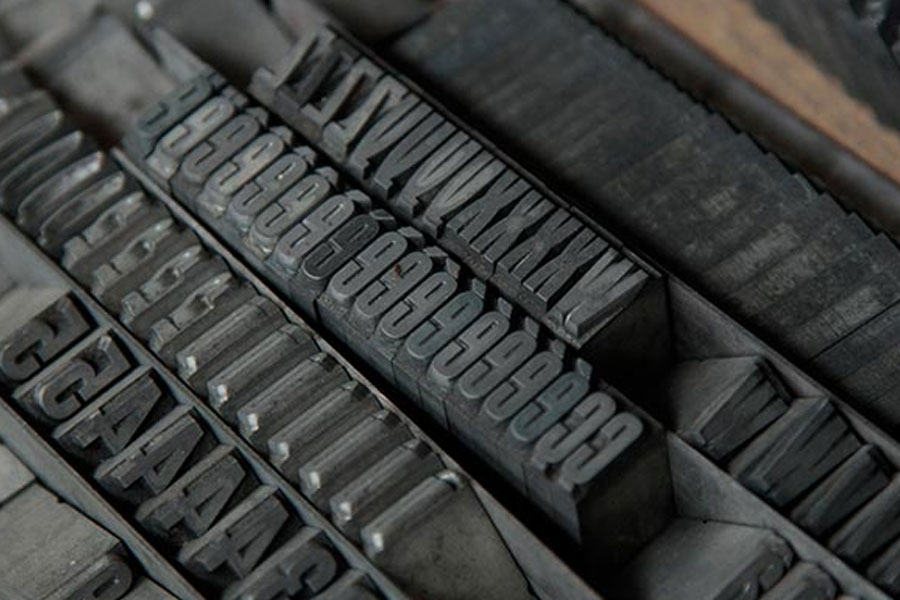 La photo représente des caractères en plomb pour l'impression de faire-part de naissance en letterpress typographie de l'atelier d'imprimerie Intaglio à Paris